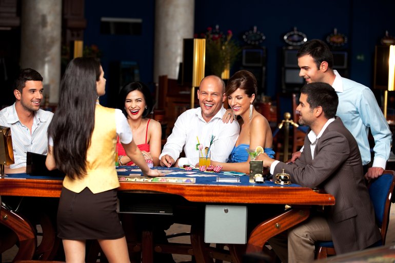 Jugadores sonrientes intentan distraer al croupier