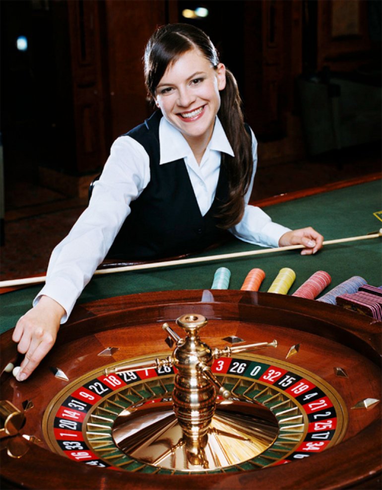  Chica linda sonriendo distribuidor, ejecuta la bola en una ruleta 